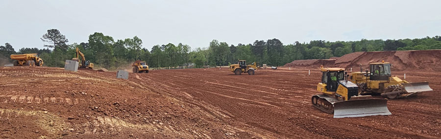 Gaines and Company bulldozers in foreground with other equipment working in the background on Deep River East project site