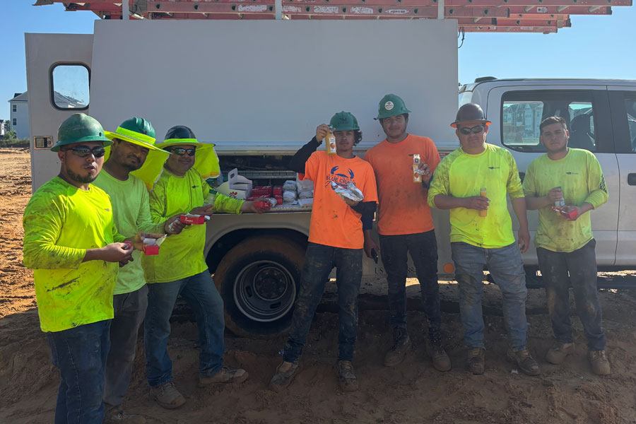 Gaines and Company crew members in front of company truck with food prior to onsite safety meeting
